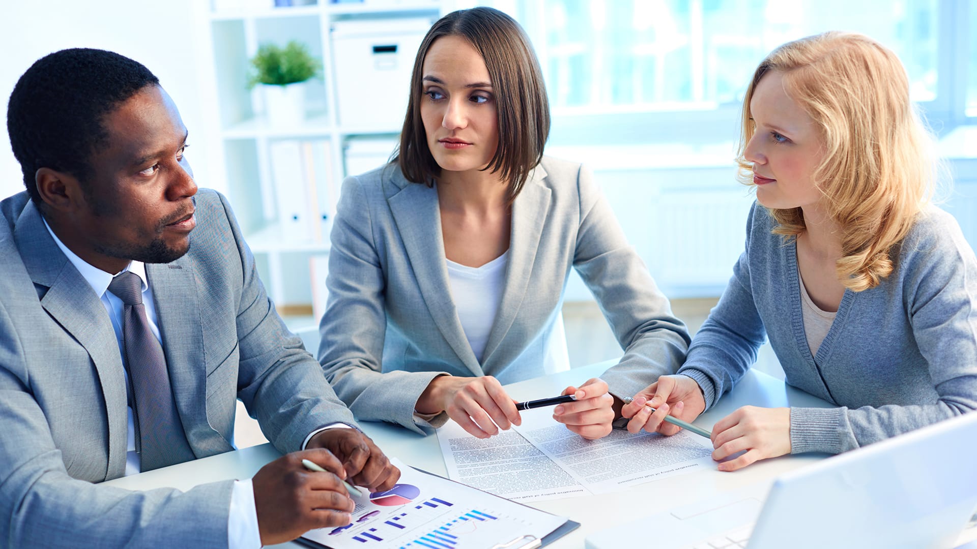 A man having a partnership meeting with two ladies, one is a realtor and the other, a loan expert.